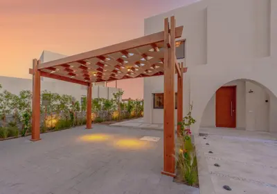 an outdoor patio with a wooden pergola at Calm 3BR House in Shedwan Gouna BBQ, Pool & Lagoon in Hurghada
