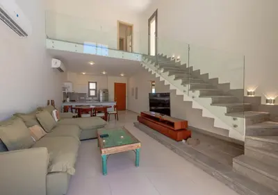 a living room with a couch and a staircase at Calm 3BR House in Shedwan Gouna BBQ, Pool & Lagoon in Hurghada