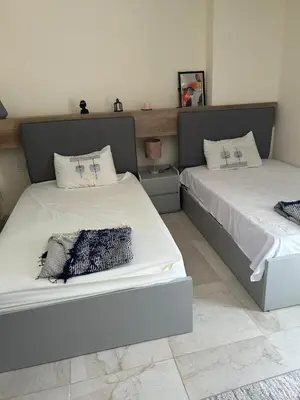 two beds sitting next to each other in a bedroom at شالية فى قرية ميراج باى الغردقة in Hurghada
