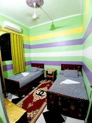 a room with two beds and a striped wall at Hamada guest house in Aswan