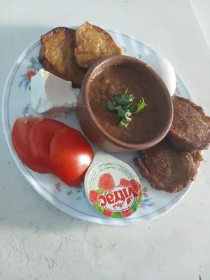 a plate of food with meatballs and soup and tomatoes at Hamada guest house in Aswan