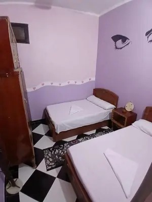 a room with three beds and a checkered floor at Hamada guest house in Aswan