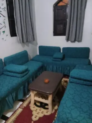 a living room with blue couches and a table at Hamada guest house in Aswan