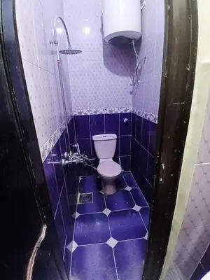 a blue tiled bathroom with a toilet in it at Hamada guest house in Aswan