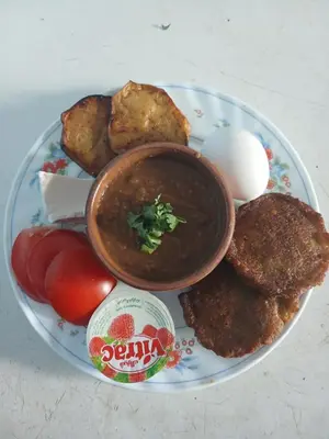 a plate of food with soup and eggs and tomatoes at Hamada guest house in Aswan