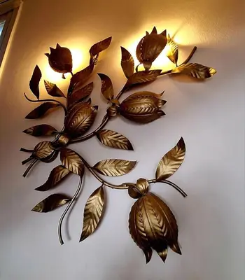 a bronze leaf wall decoration with lights on a wall at Orientalna Willa in Hurghada