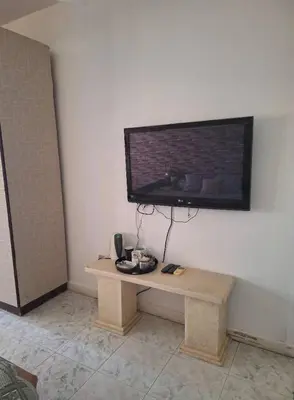a room with a table with a television on a wall at Orientalna Willa in Hurghada