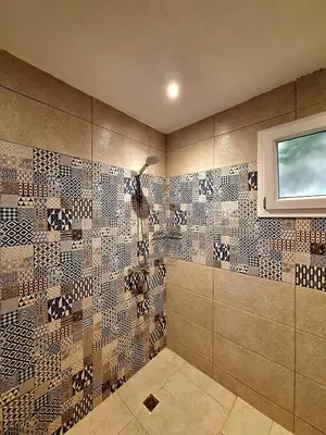 a tiled bathroom with a shower and a window at Orientalna Willa in Hurghada