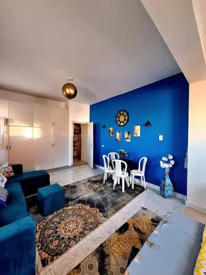 a living room with a blue wall and a table and chairs at Orientalna Willa in Hurghada