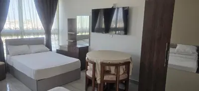 a bedroom with a bed and a stool and a mirror at فندق ميراج باي in Hurghada