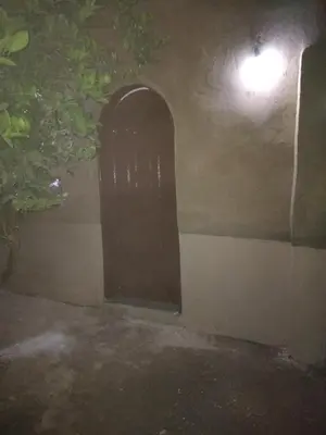 a door in the side of a house at night at Gateway to the Stars restaurant & camping in Al Aqālitah