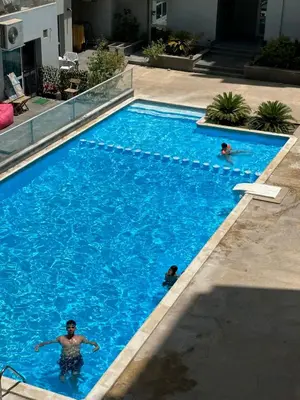 two people swimming in a large blue swimming pool at luxury apartment in Hurghada
