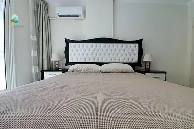 a bedroom with a large bed with two nightstands and two lamps at luxury apartment in Hurghada