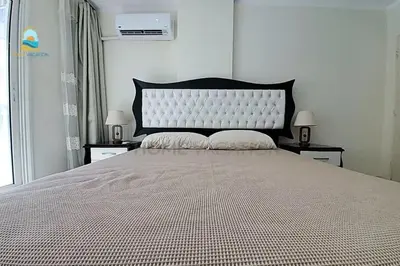 a bedroom with a large bed with two nightstands and two lamps at luxury apartment in Hurghada