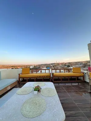 a patio with benches and tables on a roof at Ekadolli Nubian house- by kerma hospitality in Aswan