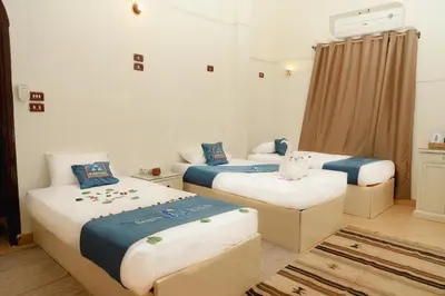 a room with two beds with blue and white at Ekadolli Nubian house- by kerma hospitality in Aswan