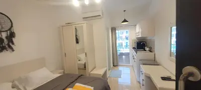 a small white room with a bed and a kitchen at Gamela in Hurghada