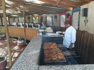 a man is cooking food on a grill at hassany hotel in Hurghada
