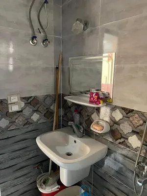 a bathroom with a sink and a mirror at شقة خلف فندق الإليزي in Hurghada