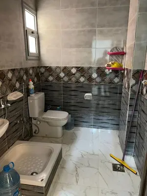 a bathroom with a shower and a toilet and a sink at شقة خلف فندق الإليزي in Hurghada