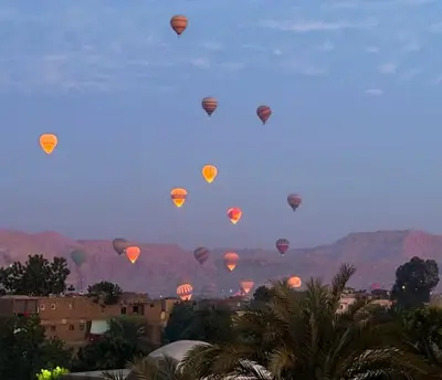 a group of hot air balloons flying in the sky at nile shores hotel in Al Aqālitah