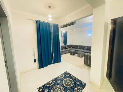 a living room with a couch and a blue curtain at nile shores hotel in Al Aqālitah