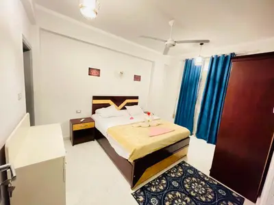 a bedroom with a large bed with blue curtains at nile shores hotel in Al Aqālitah