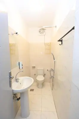 a white bathroom with a toilet and a sink at nile shores hotel in Al Aqālitah