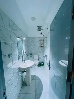 a white bathroom with a sink and a toilet at nile shores hotel in Al Aqālitah
