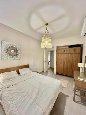 a bedroom with a large white bed and a chandelier at Villa with pool Miska Soma Bay in Hurghada