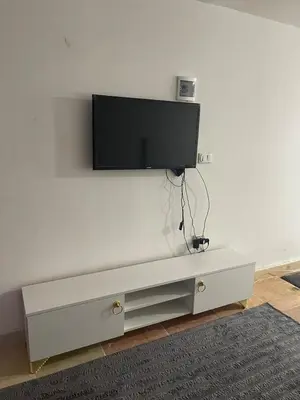 a white entertainment center with a flat screen tv on a wall at Lotus Compound in the Inter Area in Hurghada