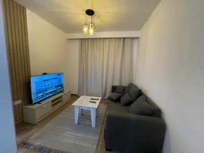 a living room with a couch and a tv at 1BR Relaxing Seaside Retrear Shal Hasheesh in Hurghada