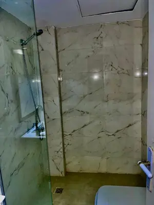 a bathroom with a glass shower and a toilet at Palma Resort in Hurghada
