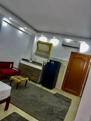 a living room with a refrigerator and a red couch at Palma Resort in Hurghada