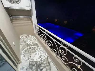 a balcony with a blue seat and two stools at Hub resort Aqua park in Hurghada