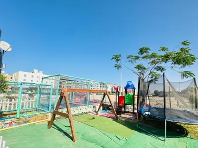a playground with a tree and a swing at Hub resort Aqua park in Hurghada