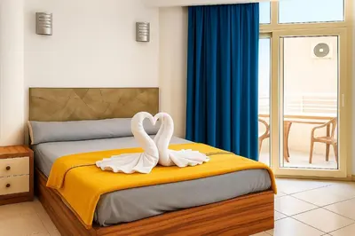 two swans sitting on a bed in a bedroom at Majestic apartments in Hurghada