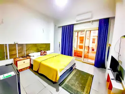 a bedroom with a bed with a yellow blanket at Majestic apartments in Hurghada