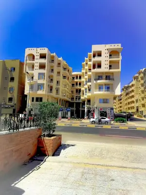 an empty street in front of tall apartment buildings at Majestic apartments in Hurghada
