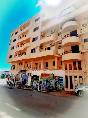 a tall building with a car parked in front of it at Majestic apartments in Hurghada