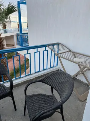 a chair and a table on a balcony at Dream Chalet In Mirage Bay Resort in Hurghada