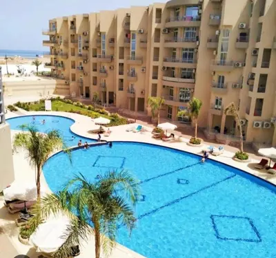 a large swimming pool in front of a building at marvel princes in Hurghada