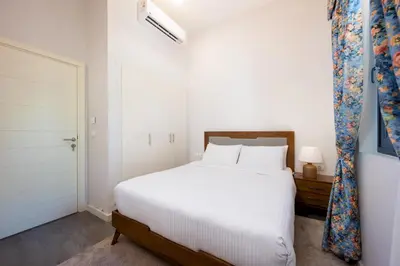 a bedroom with a white bed and a white door at VESTA - El Gouna Residence in Hurghada