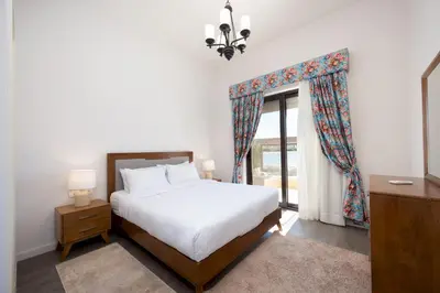a bedroom with a bed and a large window at VESTA - El Gouna Residence in Hurghada