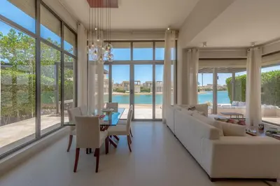 a living room with a couch and a table and chairs at The Lake View Villa 4BR at Tawila El Gouna in Hurghada