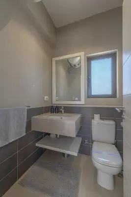 a bathroom with a sink and a toilet and a mirror at The Lake View Villa 4BR at Tawila El Gouna in Hurghada