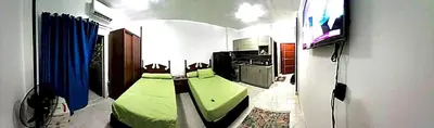 a bedroom with a green bed and a flat screen tv at Tiba view in Hurghada