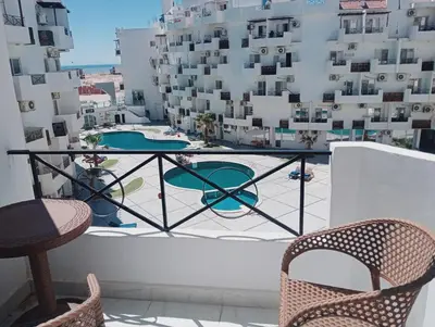 a balcony with chairs and a table and some buildings at Tiba view in Hurghada