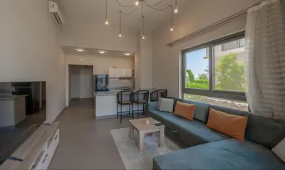 a living room with a blue couch and a kitchen at Luxury Stays in Tawila El Gouna in Hurghada