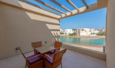 a balcony with a table and chairs and a view of the water at Luxury Stays in Tawila El Gouna in Hurghada